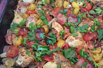 Hühnchen auf dem Backblech mit geschmolzenen Tomaten und Pancetta