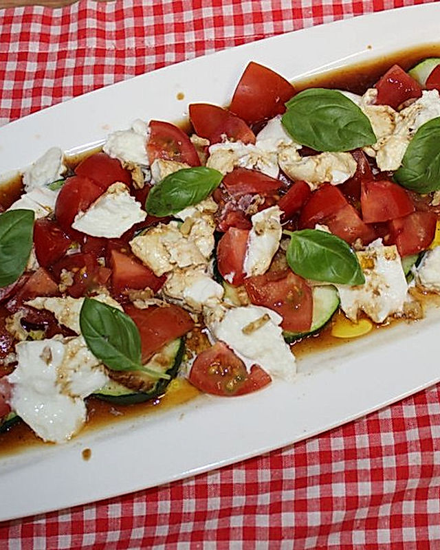 Zucchiniplatte vom Grill mit Tomaten, Mozzarella und frischem Basilikum