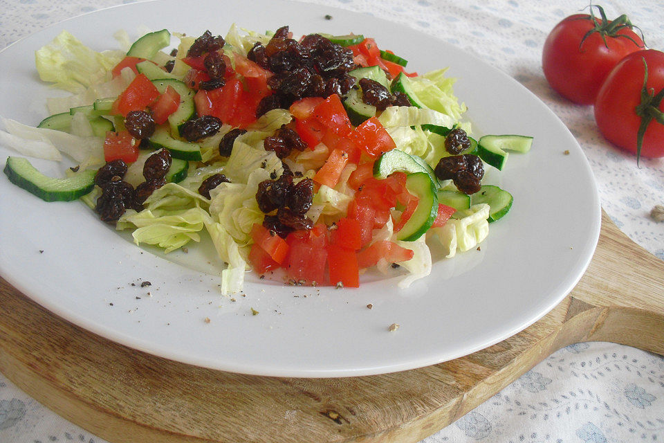 Grüner Salat mit Tomaten, Gurken und Sultaninen