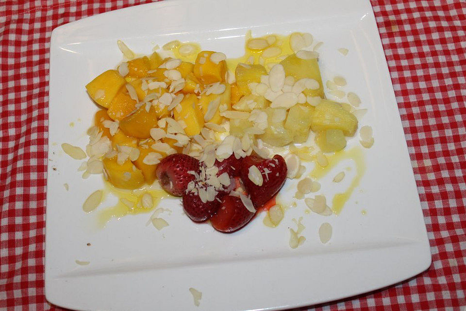 Ananans-Mango-Erdbeer-Salat mit Limetten-Honig-Dressing und Mandelblättchen