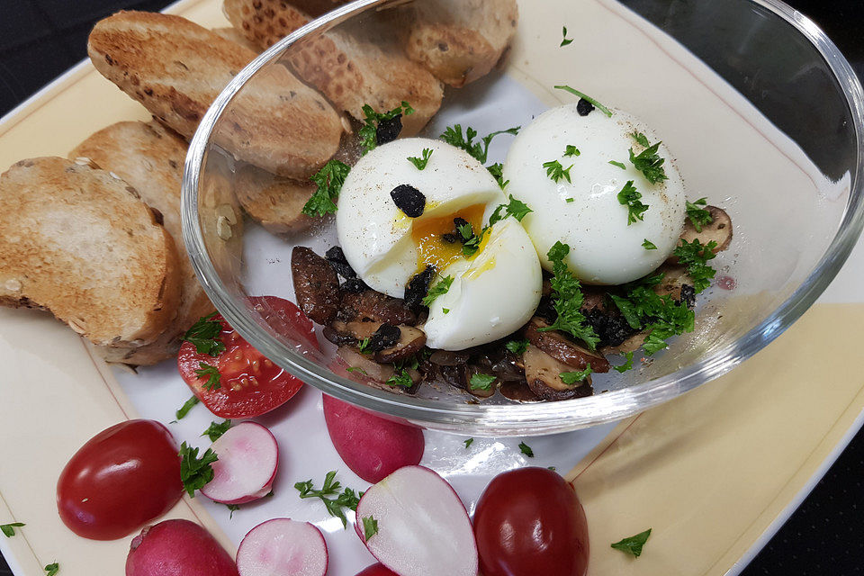 Eier im Glas auf Champignons in Kräuterbutter