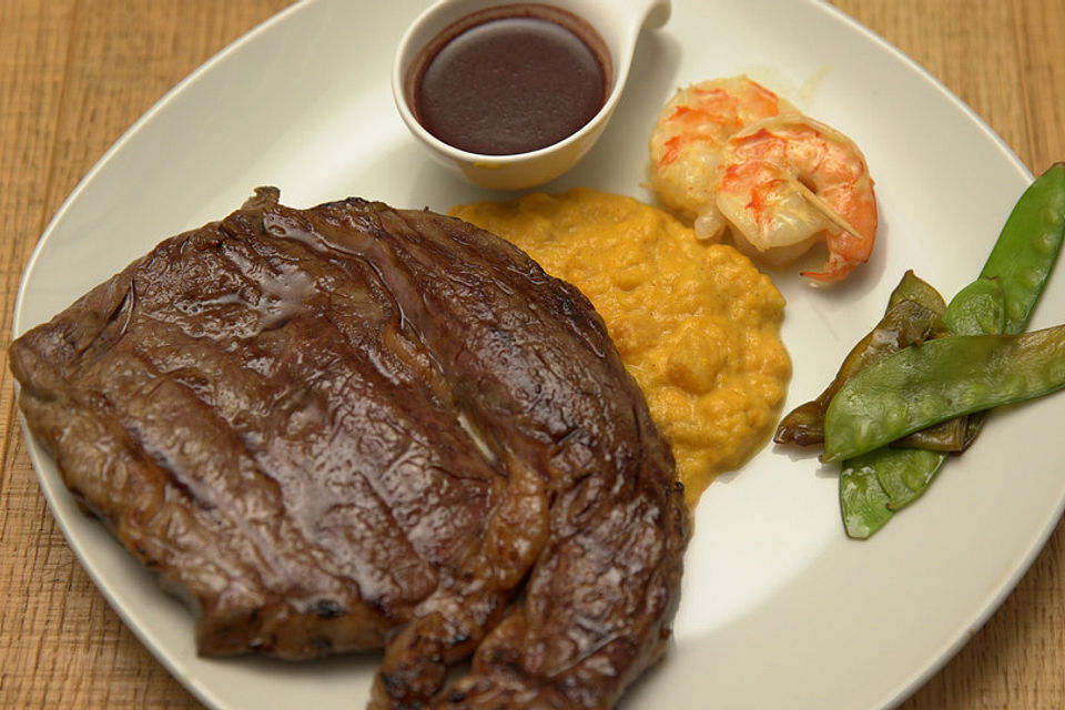 Surf & Turf: Dry Aged Rind mit Riesengarnele auf einem Kürbis-Süßkartoffelstampf und Portwein-Zuckerschoten