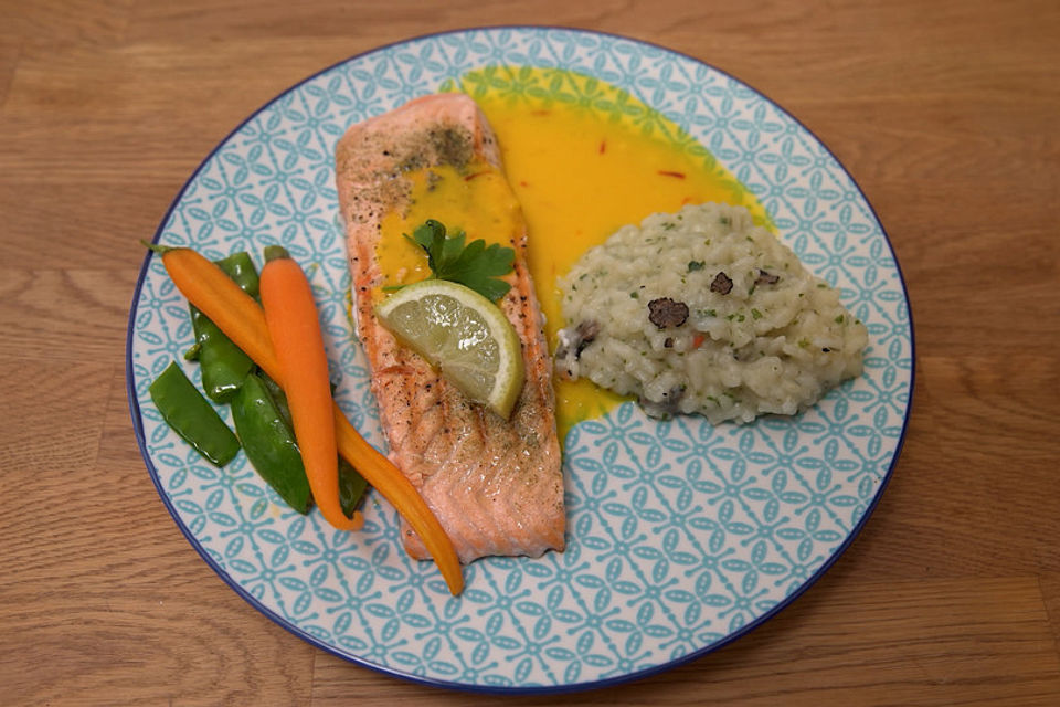 Gegrilltes Lachsfilet an Trüffelrisotto mit Schoten und kandierten Möhren an einer Safransoße