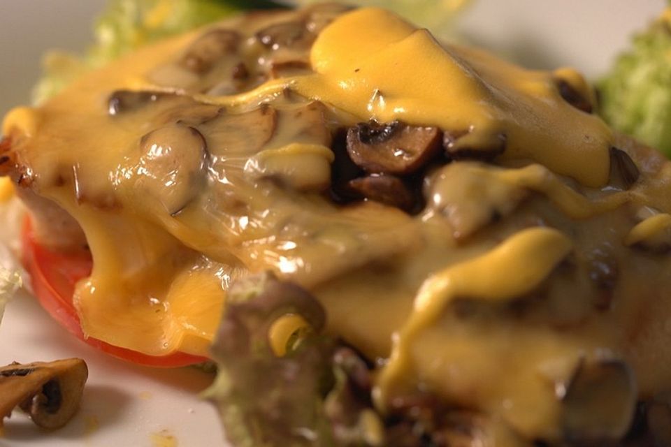 Glückstädter Teufel – gebratenes Putenschnitzel mit Champignons, Käse und Sauce Hollandaise überbacken auf Salatbett, dazu Bratkartoffeln