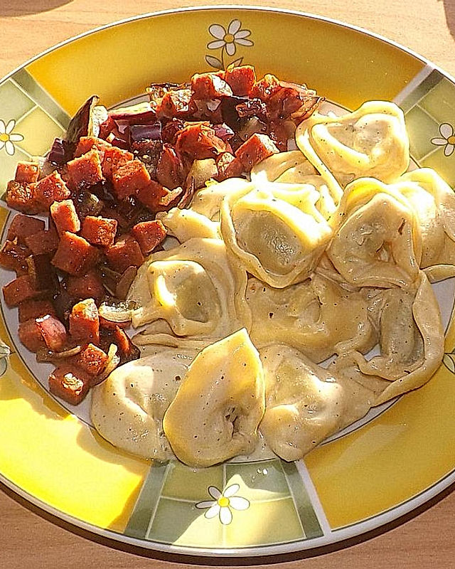 Gebratene Salami-Zwiebelwürfel und Tortellinisalat mit Buttermilch-Crème fraîche-Senf-Dressing