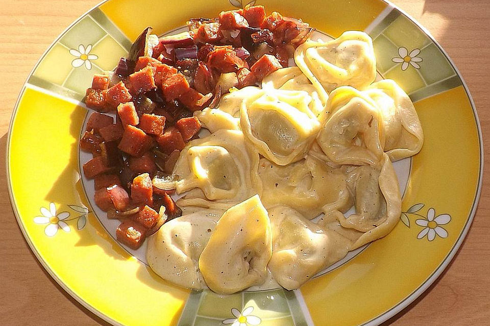 Gebratene Salami-Zwiebelwürfel und Tortellinisalat mit Buttermilch-Crème fraîche-Senf-Dressing