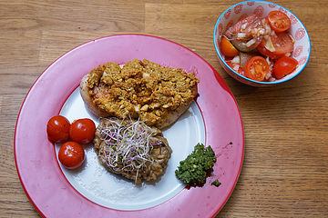Bierhefehühnchen mit Curry-Cashewnusskruste und Vanilletomate auf Steinpilzrisotto an frischem Tomatensalat und Pesto
