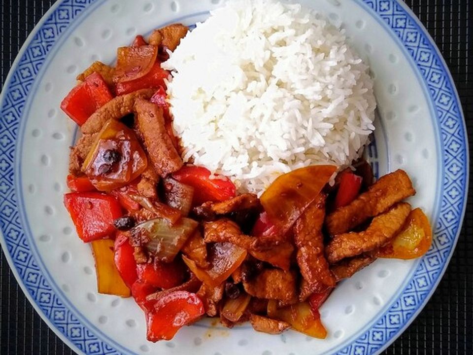 Schweinefleisch mit Paprika, Zwiebeln und schwarzen Bohnen in Chiliöl ...