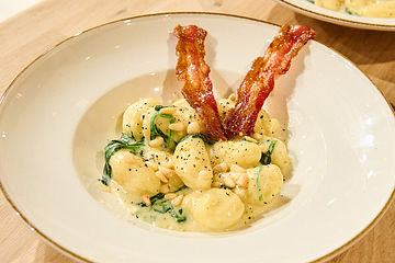 Selbstgemachte Gnocchi in Spinat-Gorgonzolasauce mit Pinienkernen und Bacon