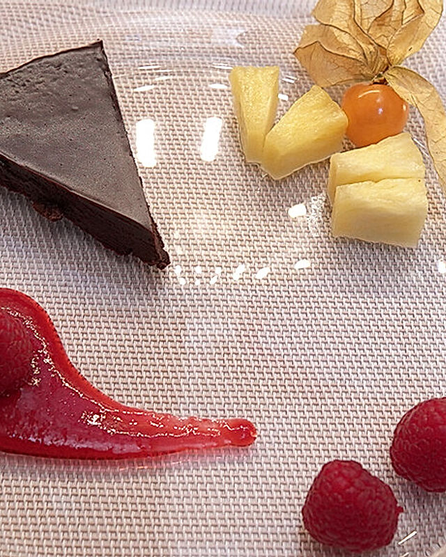 Dekadenter Schokoladenkuchen, Himbeersoße und Mango-Mousse
