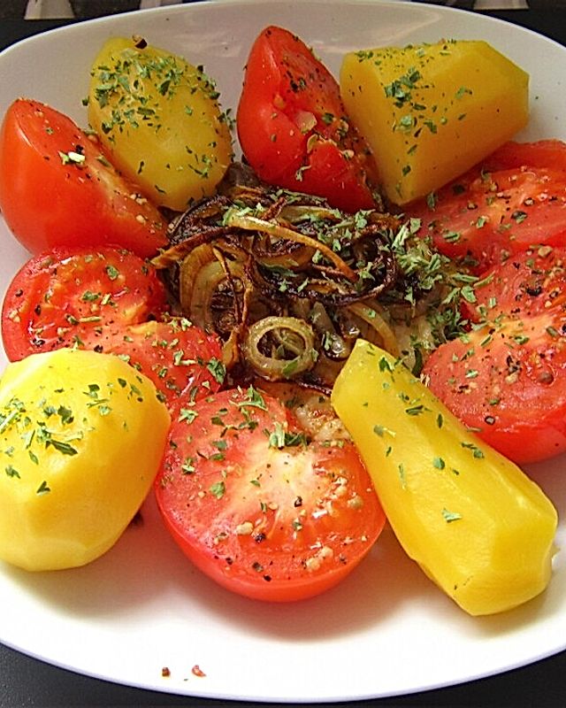 Gebratener Stör mit Zwiebeln und gedämpften Kartoffeln und Tomaten