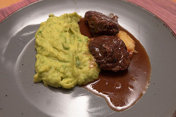 Geschmorte Schweinebäckchen auf karamellisierter Apfelscheibe mit Kartoffel-Erbspüree und Portweinjus