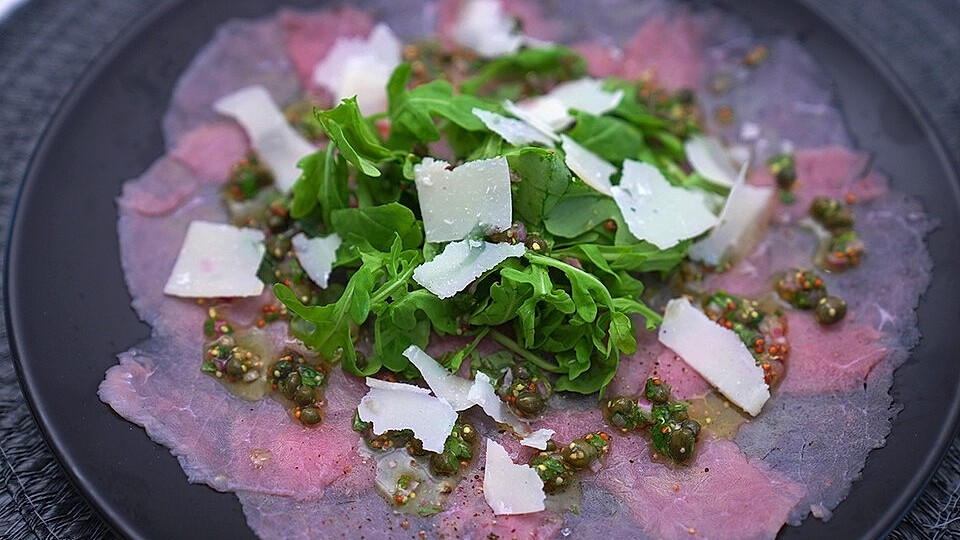 Kalbscarpaccio mit Kapern-Vinaigrette, Rucola und gehobeltem Parmesan ...