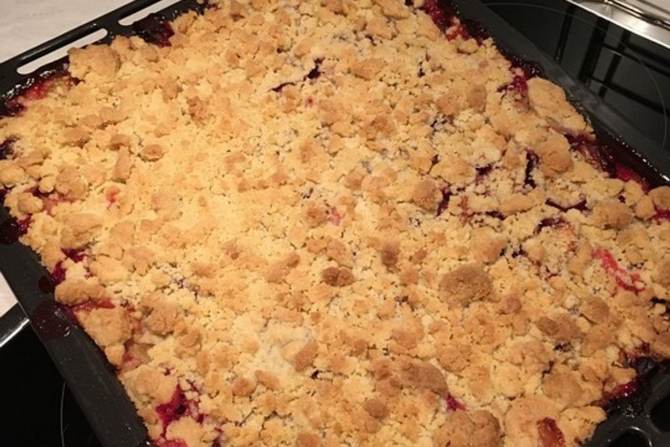 Pflaumenkuchen mit Streuseln auf dem Blech