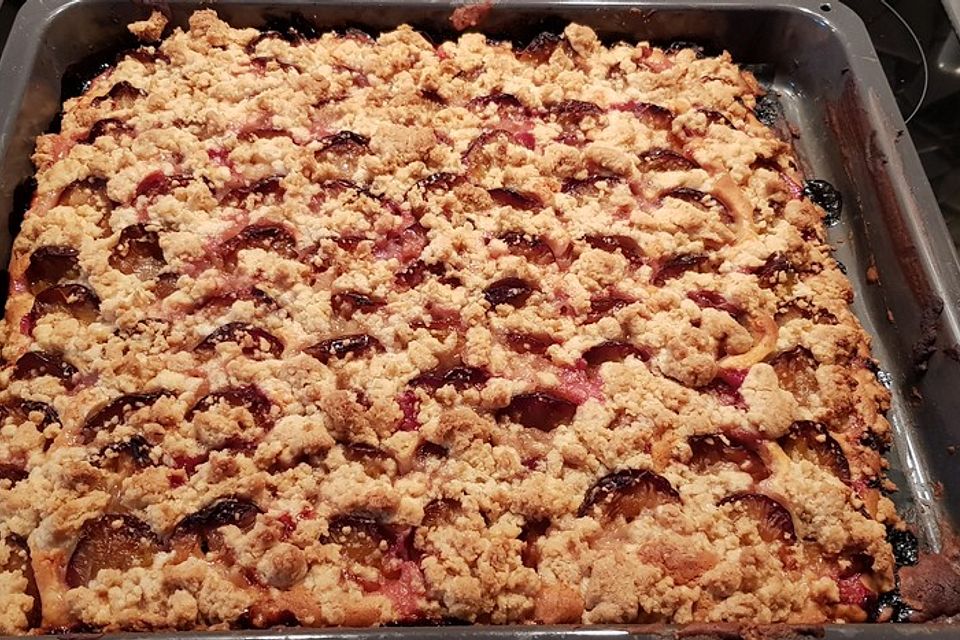 Pflaumenkuchen mit Streuseln auf dem Blech