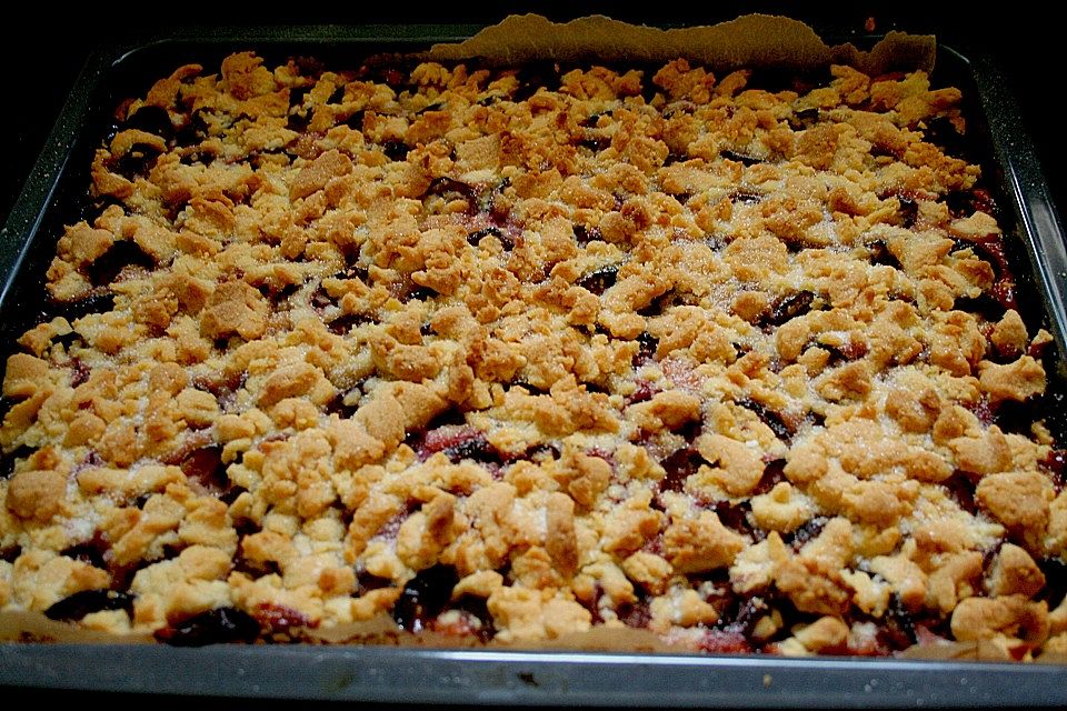 Pflaumenkuchen mit Streuseln auf dem Blech