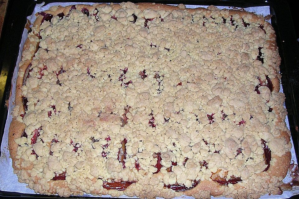 Pflaumenkuchen mit Streuseln auf dem Blech