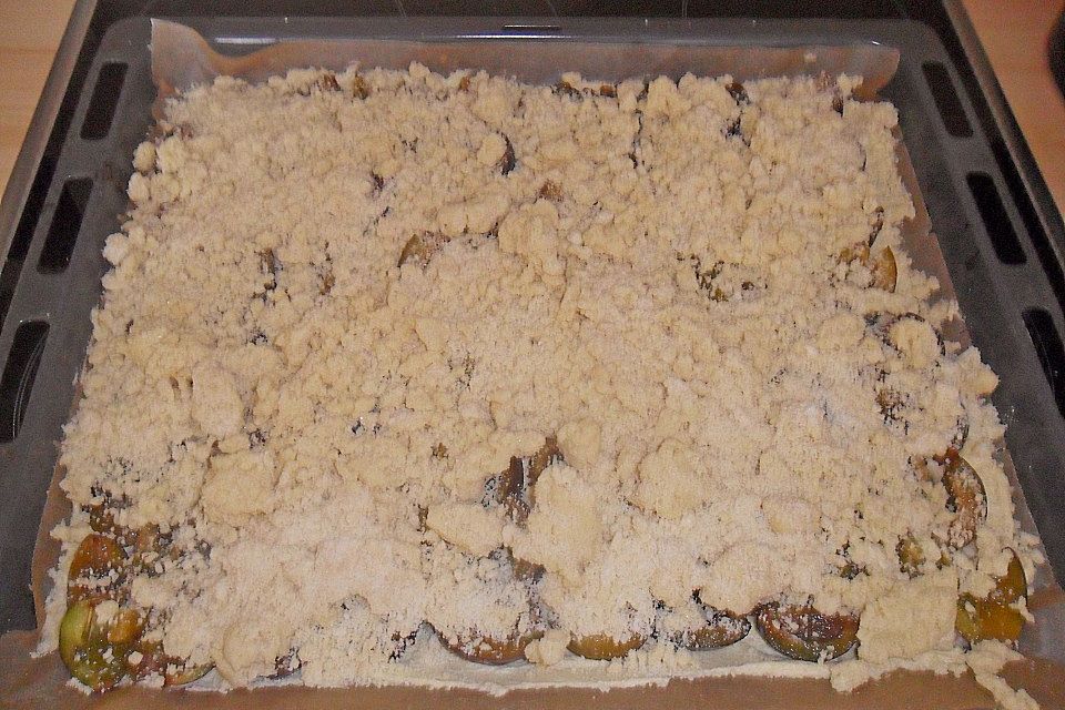 Pflaumenkuchen mit Streuseln auf dem Blech