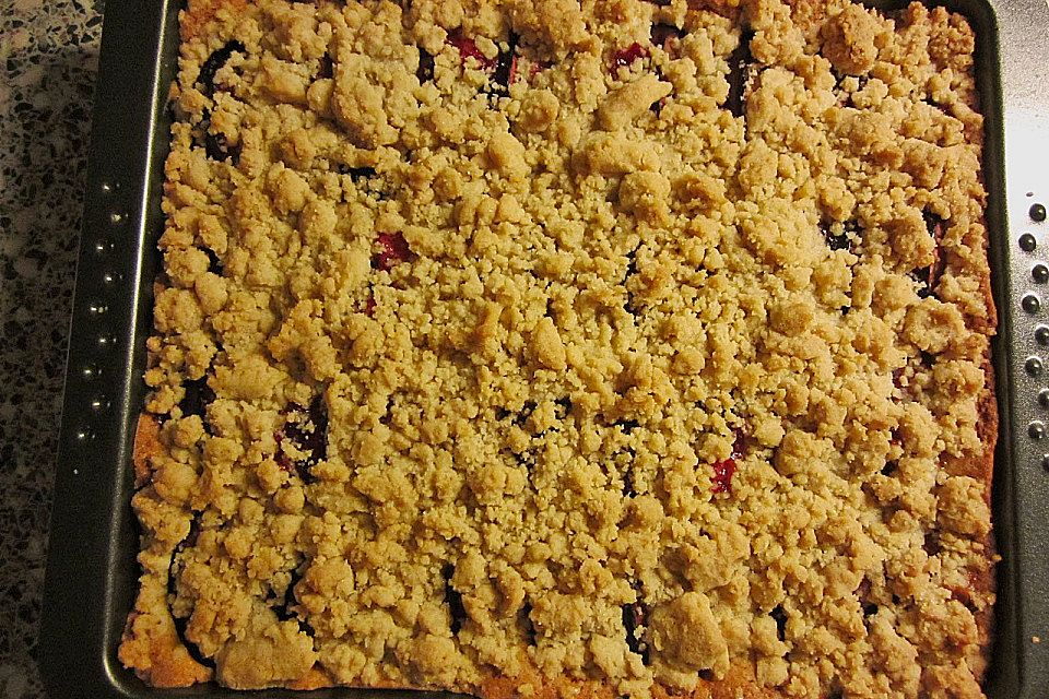 Pflaumenkuchen mit Streuseln auf dem Blech