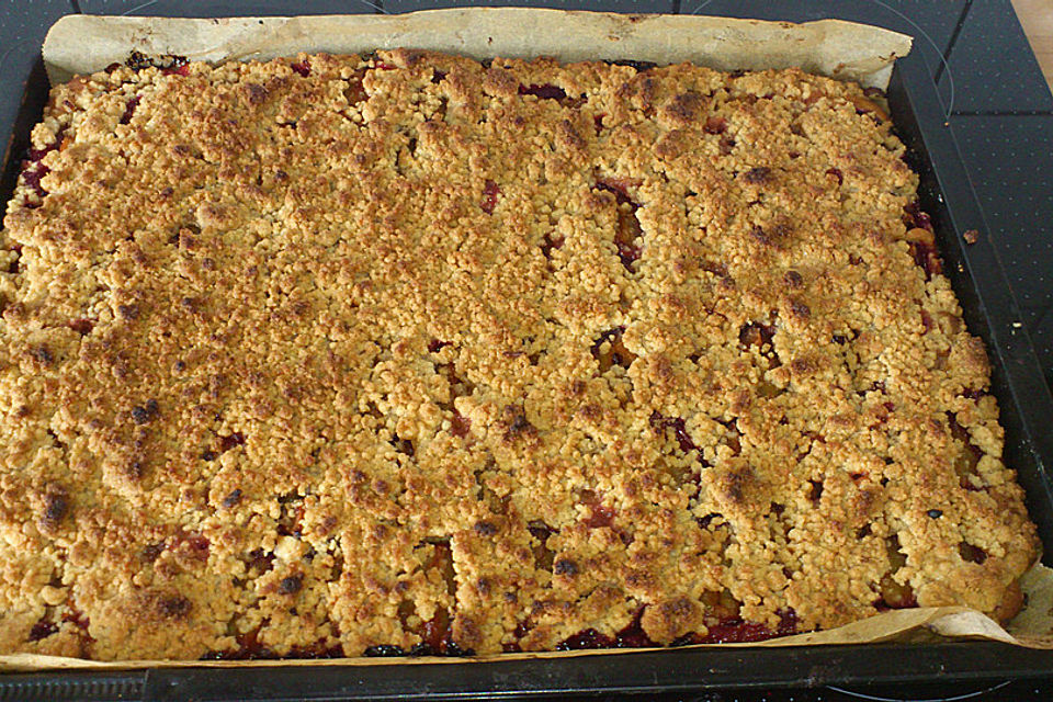 Pflaumenkuchen mit Streuseln auf dem Blech