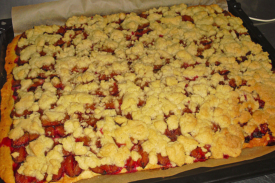 Pflaumenkuchen mit Streuseln auf dem Blech