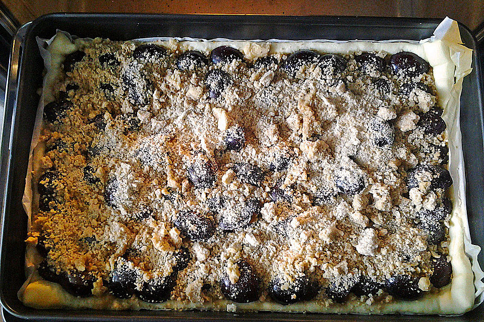 Pflaumenkuchen mit Streuseln auf dem Blech