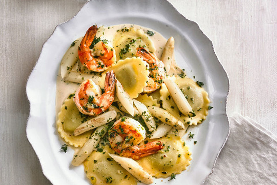 Ravioli mit gebratenen Garnelen und Spargel in Kräutersahne