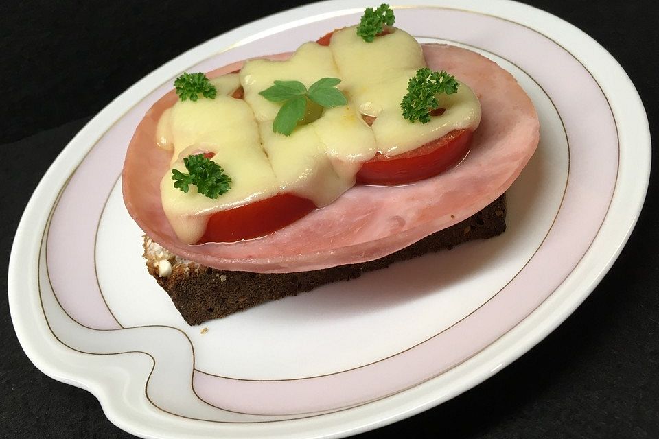 Körnerbrot mit Schinken, Tomaten und Käse überbacken