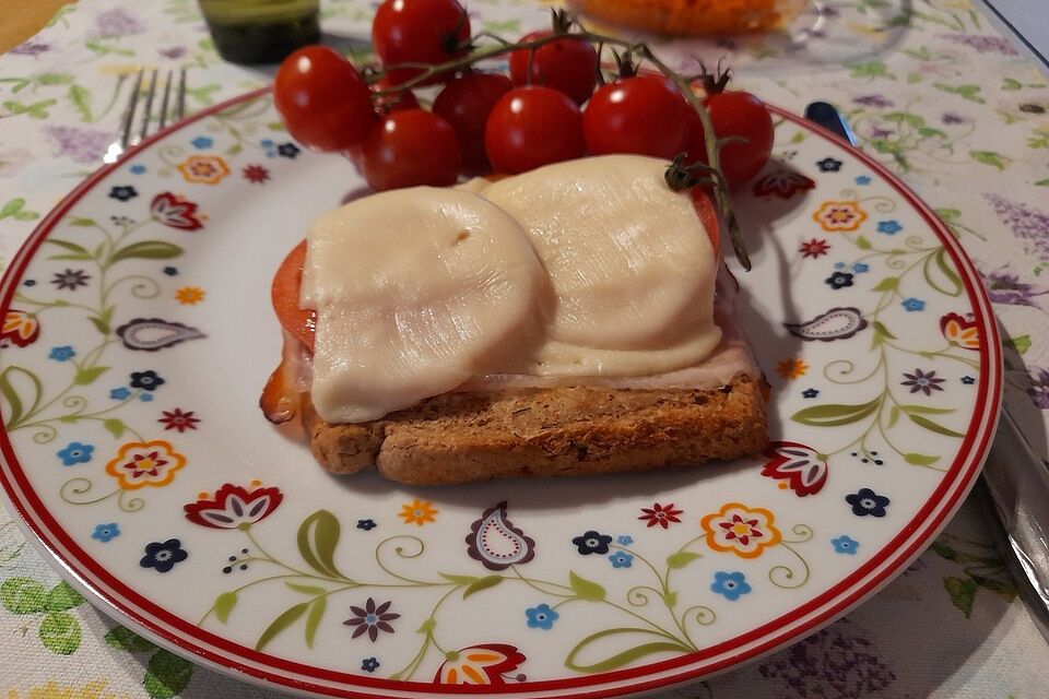 Körnerbrot mit Schinken, Tomaten und Käse überbacken