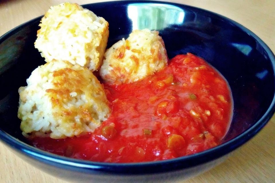 Reisbällchen auf Tomatengemüse