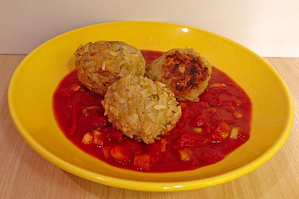 Reisbällchen auf Tomatengemüse