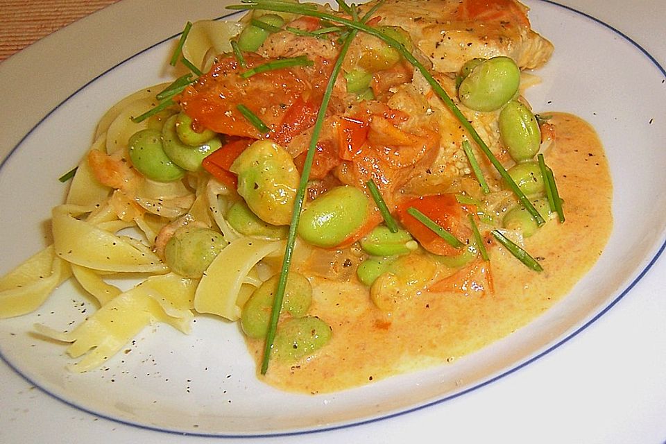 Gebratene marinierte Putenstreifen auf Bandnudeln mit würziger Tomaten - Sahne - Sauce