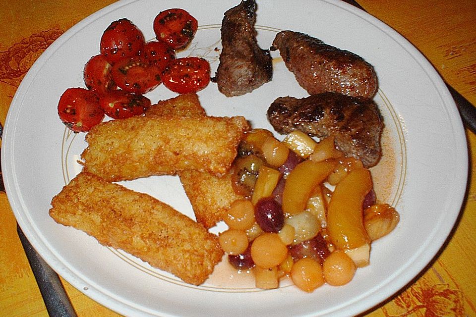 Straußensteaks mit Kartoffel - Gouda - Stäbchen an Cherrytomaten und Tropenfrüchten