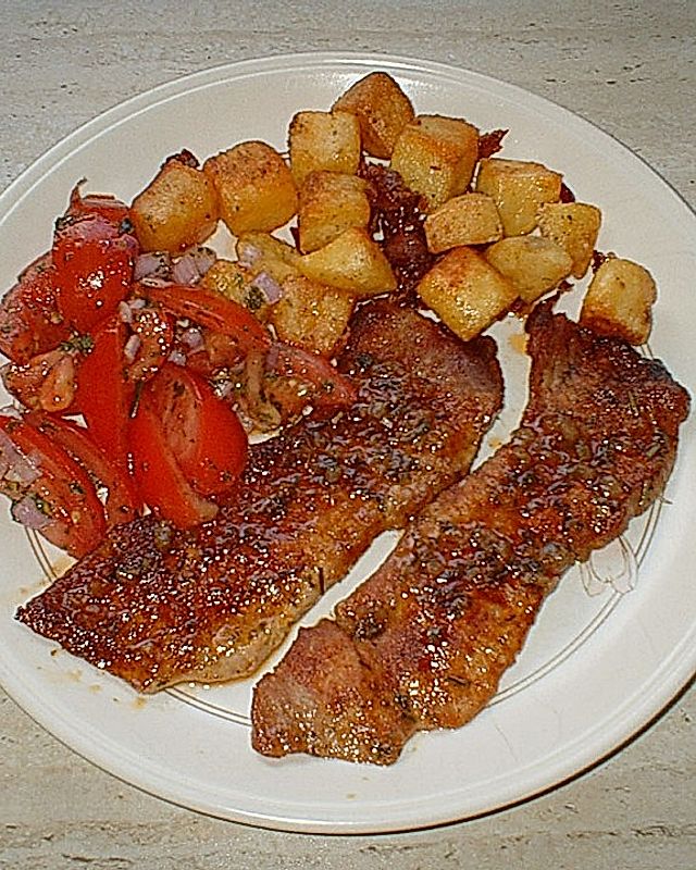 Schweineschnitzel mit Tomatensalat an groben Kartoffelwürfeln