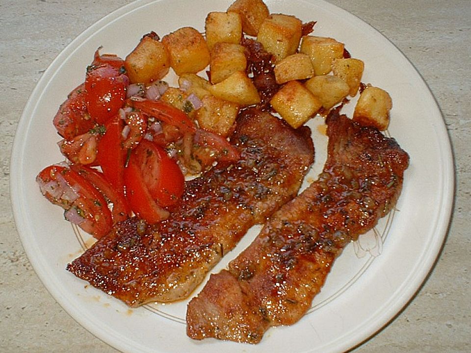 Schweineschnitzel mit Tomatensalat an groben Kartoffelwürfeln von ...