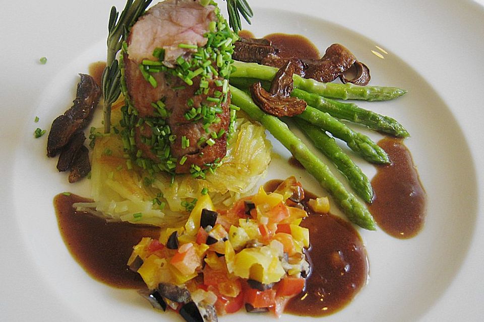 Schweinefilet auf Kartoffelstroh mit grünem Thaispargel, Steinpilzen und Paprika-Oliven-Gemüse